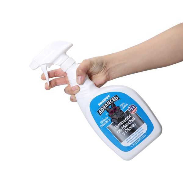 SuniEnzimatico Gato aplicando Botella de SuniEnzimático Gato 946 ml, con la etiqueta visible y tomada por una mano en posición de aplicación.